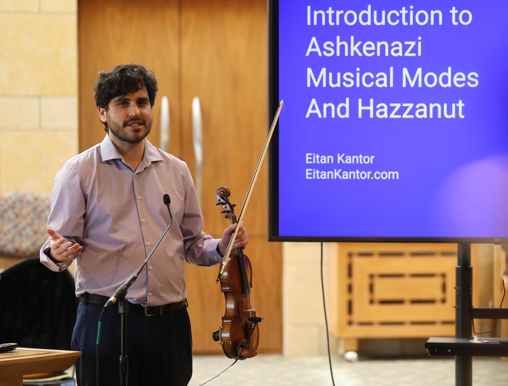 Eitan Kantor leading a lunch-and-learn on Ashkenazi musical modes, presenting beside a screen.