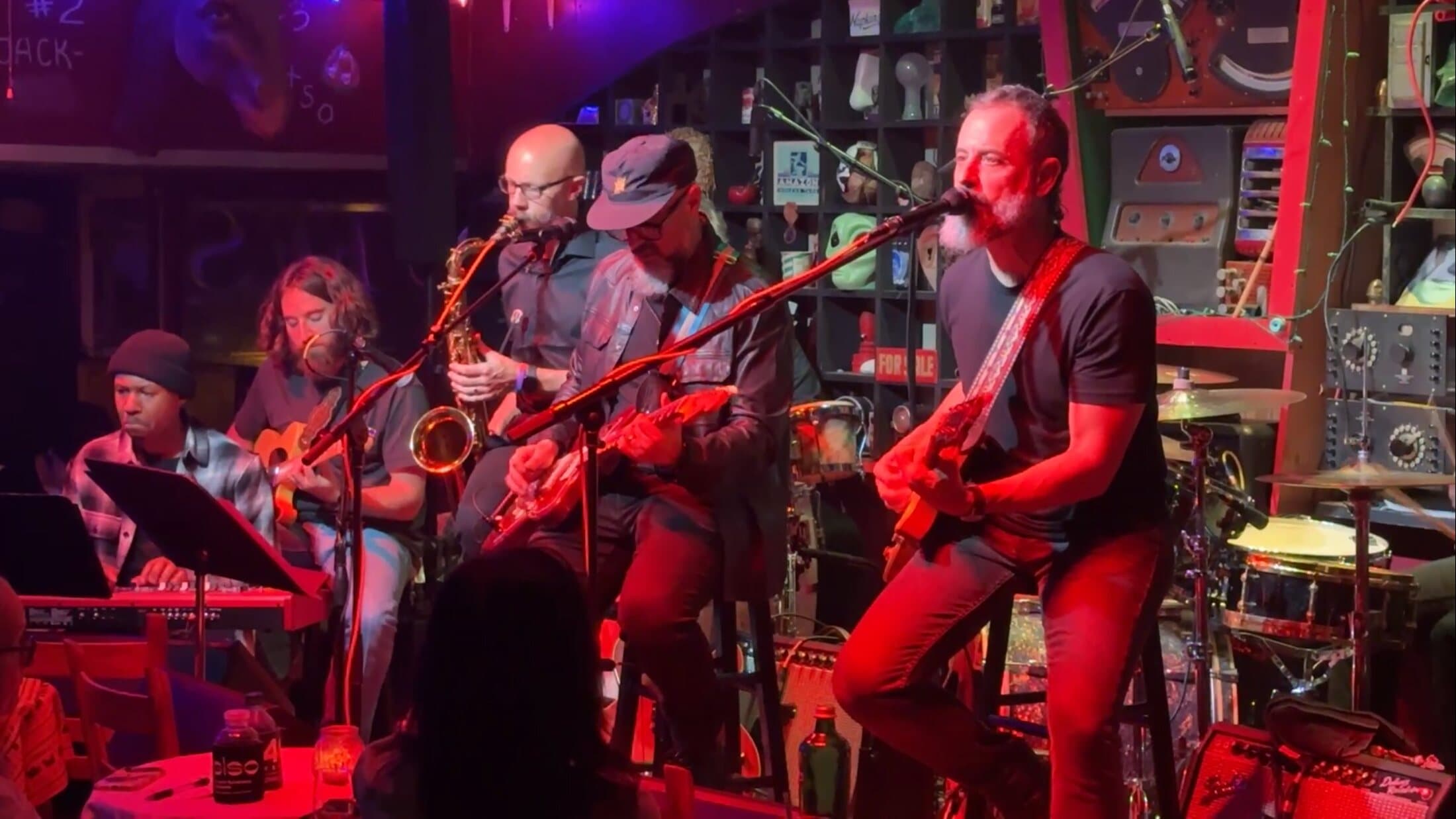 The CRC House Band performing on stage under colored concert lighting.